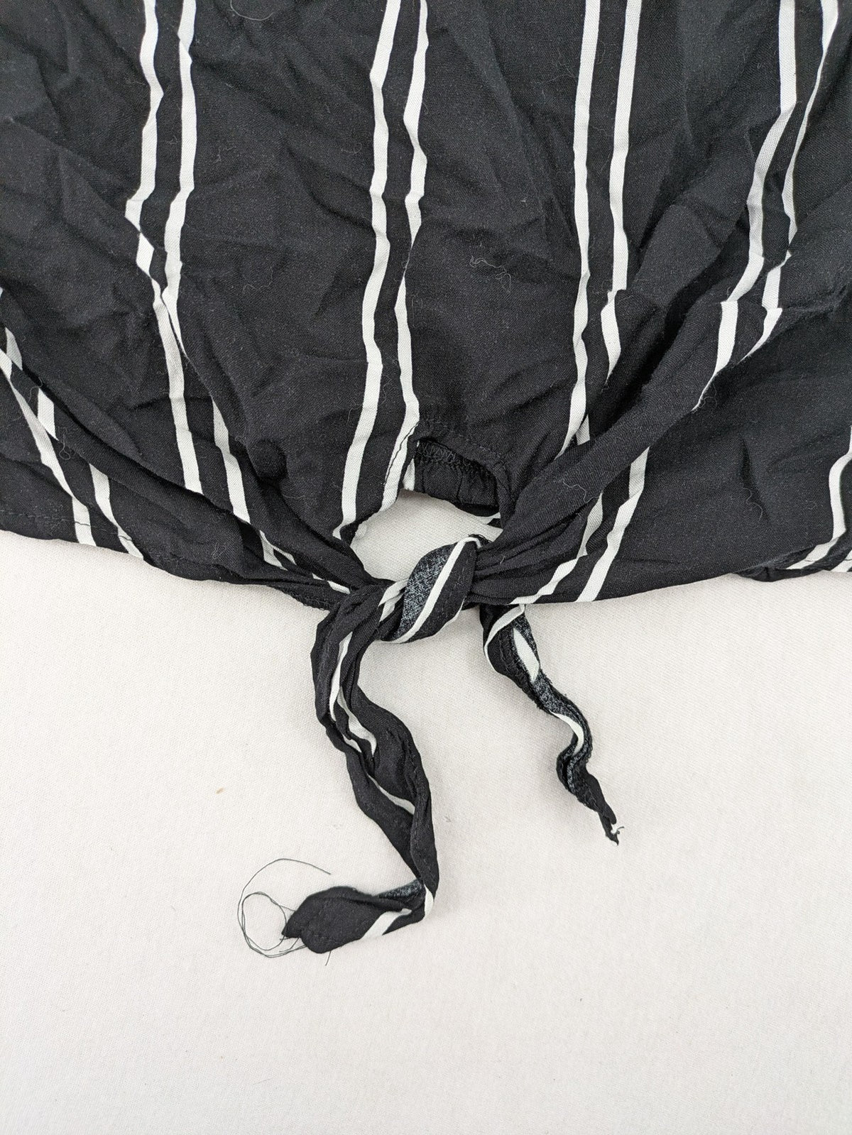Hailys black and white striped crop top with front tie and off-shoulder design.