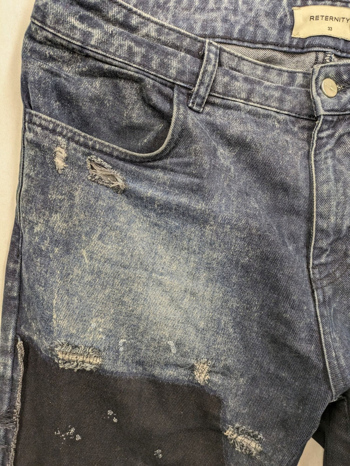 Reternity straight jeans blue black patchwork design with distressed details and frayed seams.