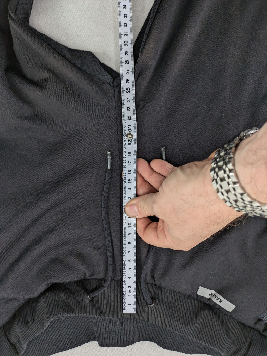 Kalenji black loungewear pants with grey accents and zippered side pockets.