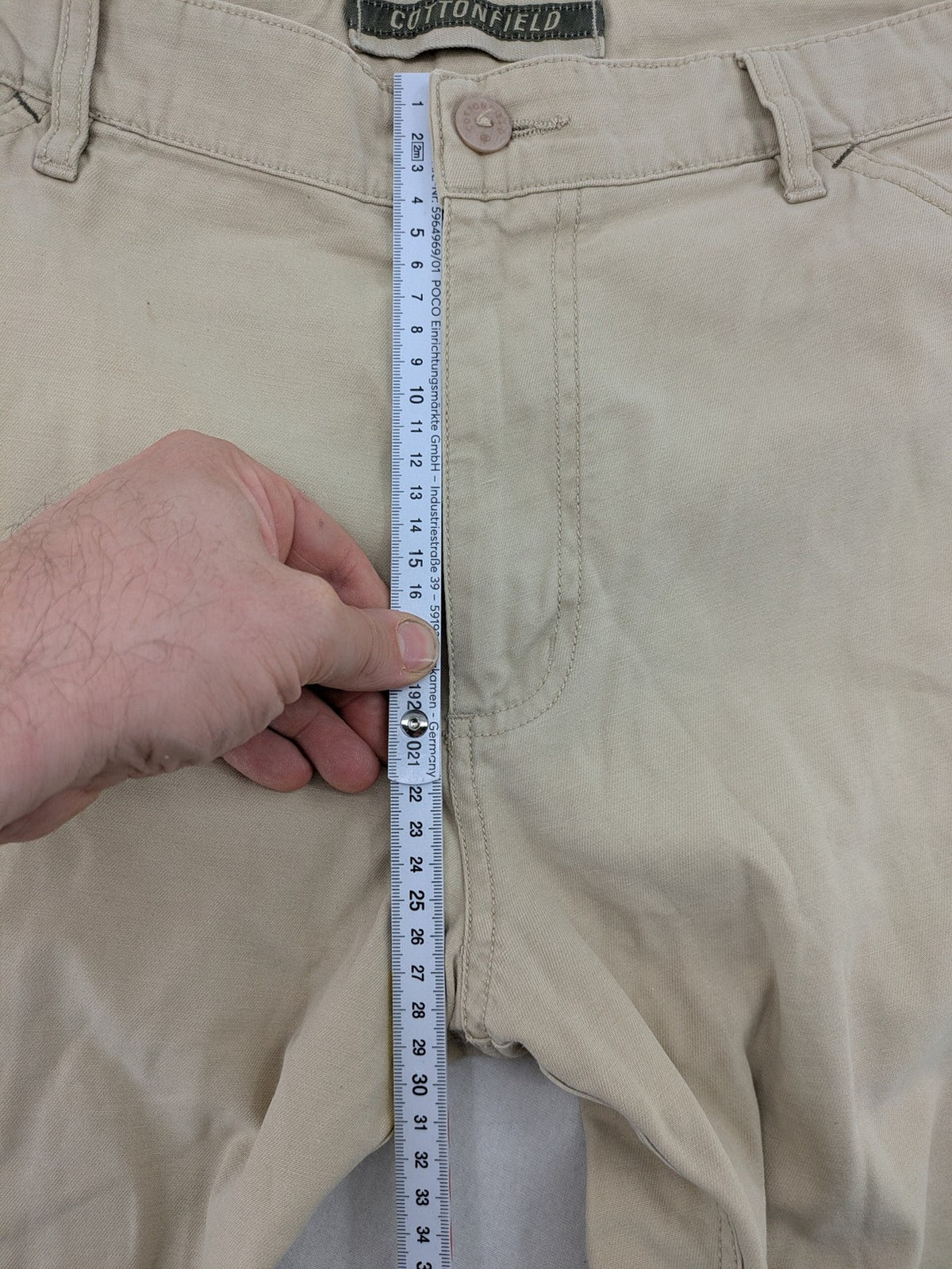 Cottonfield beige cargo pants with multiple pockets and button flaps.