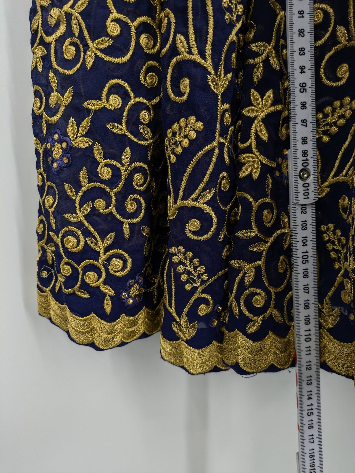 Bollywood bridal party dress gold with intricate blue embroidery and flowing Anarkali silhouette.
