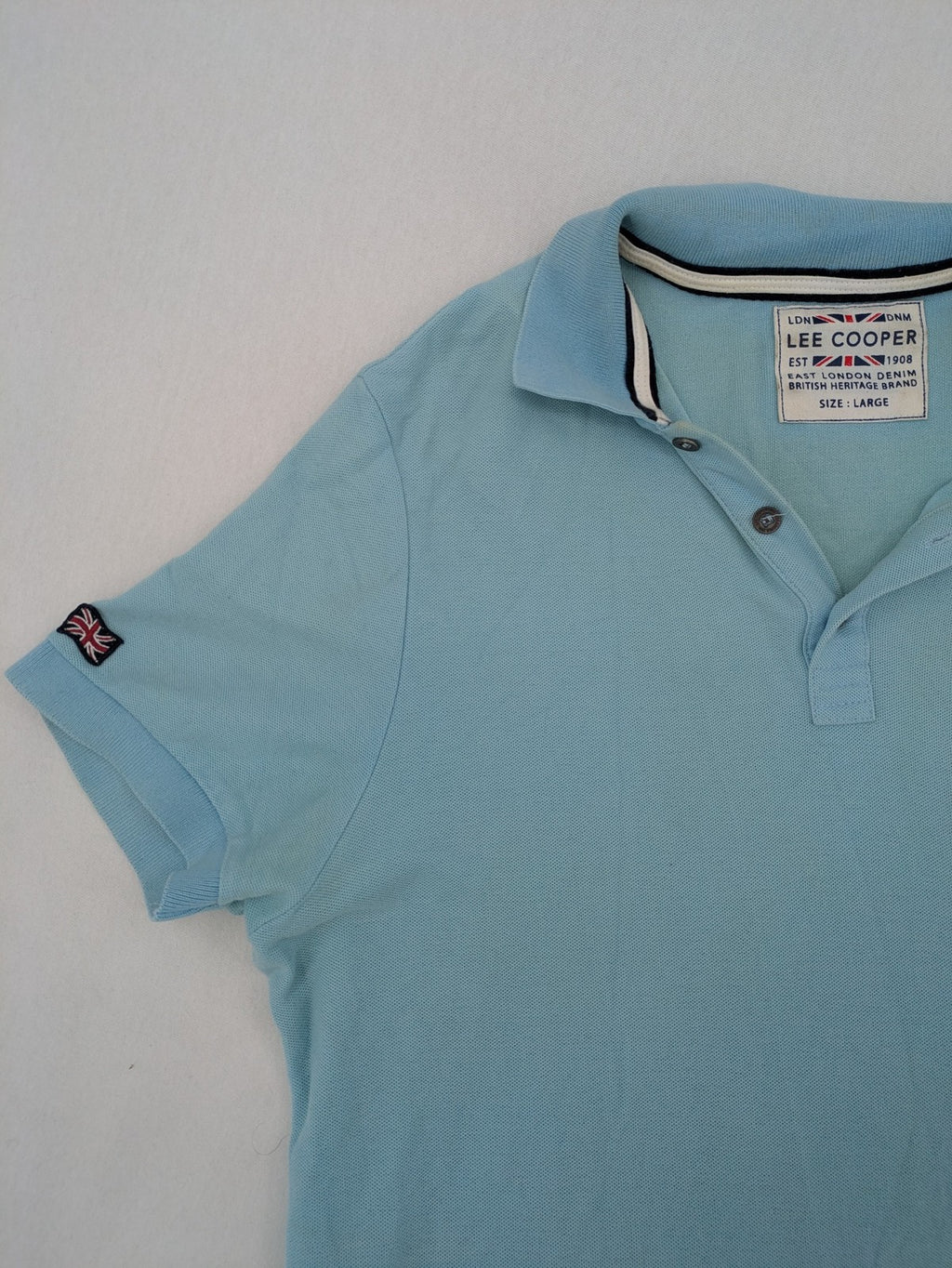 Lee Cooper blue polo shirt with embroidered logo and Union Jack patch on sleeve.