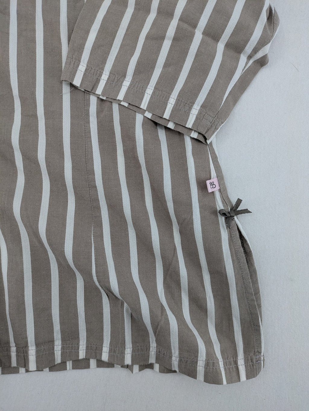 Body Sunday beige and white striped loungewear top with bow accents and button placket.