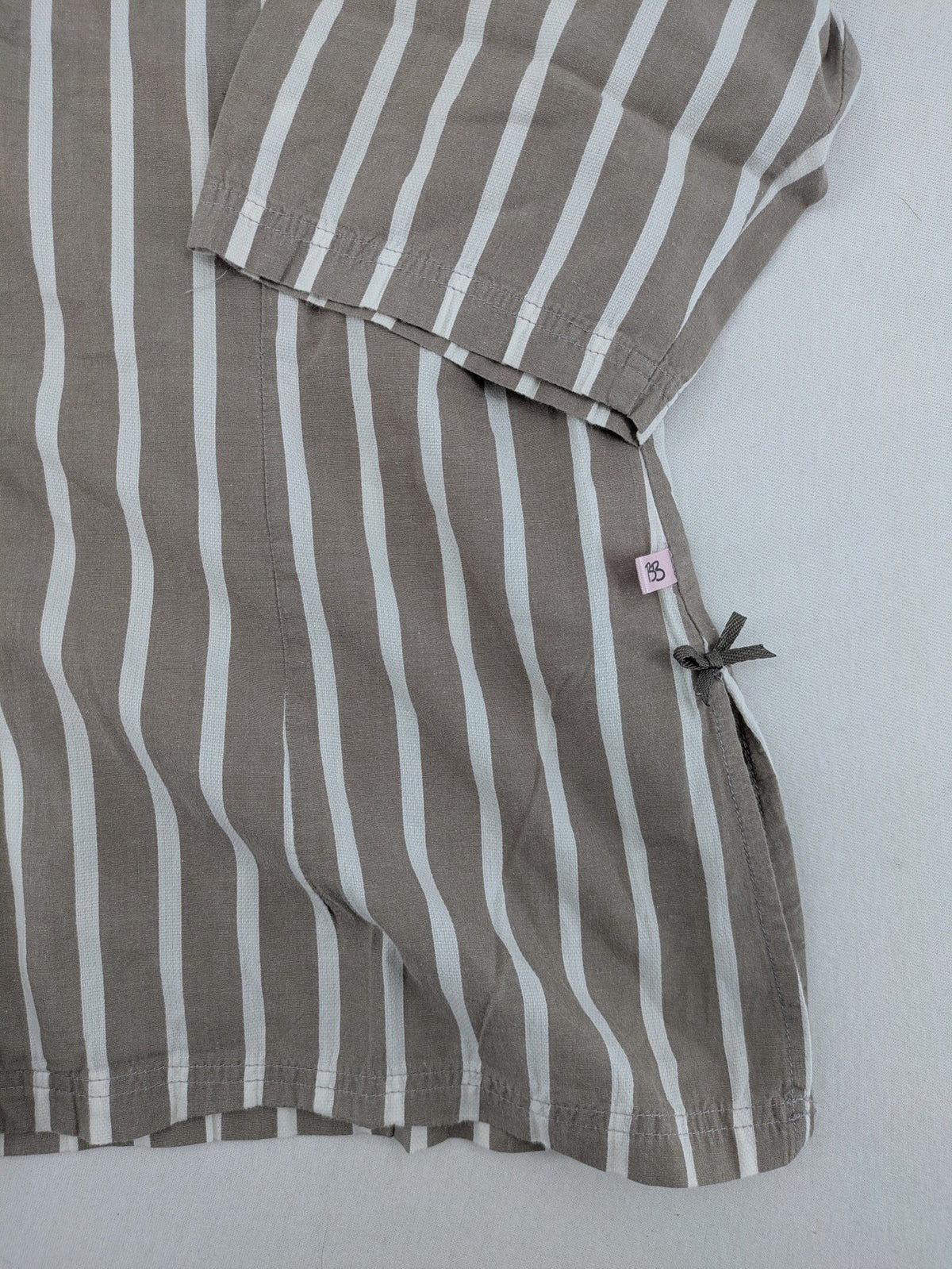 Body Sunday beige and white striped loungewear top with bow accents and button placket.