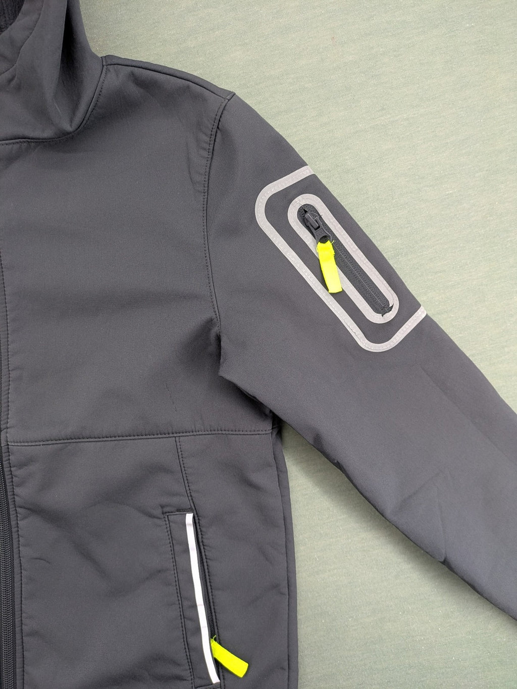 Yigga grey softshell coat with fleece lining, hood, and reflective details.