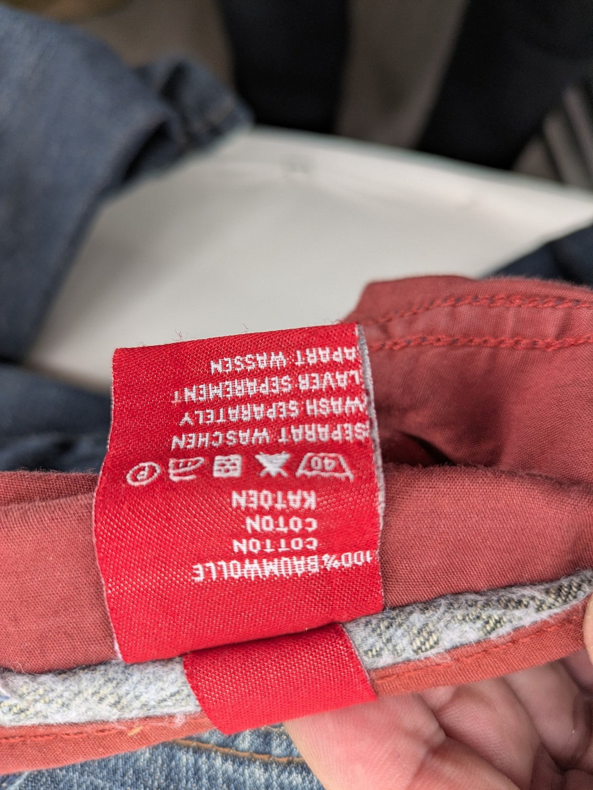 Indygo blue straight jeans 5-pocket style with subtle red pocket detail, cotton material.