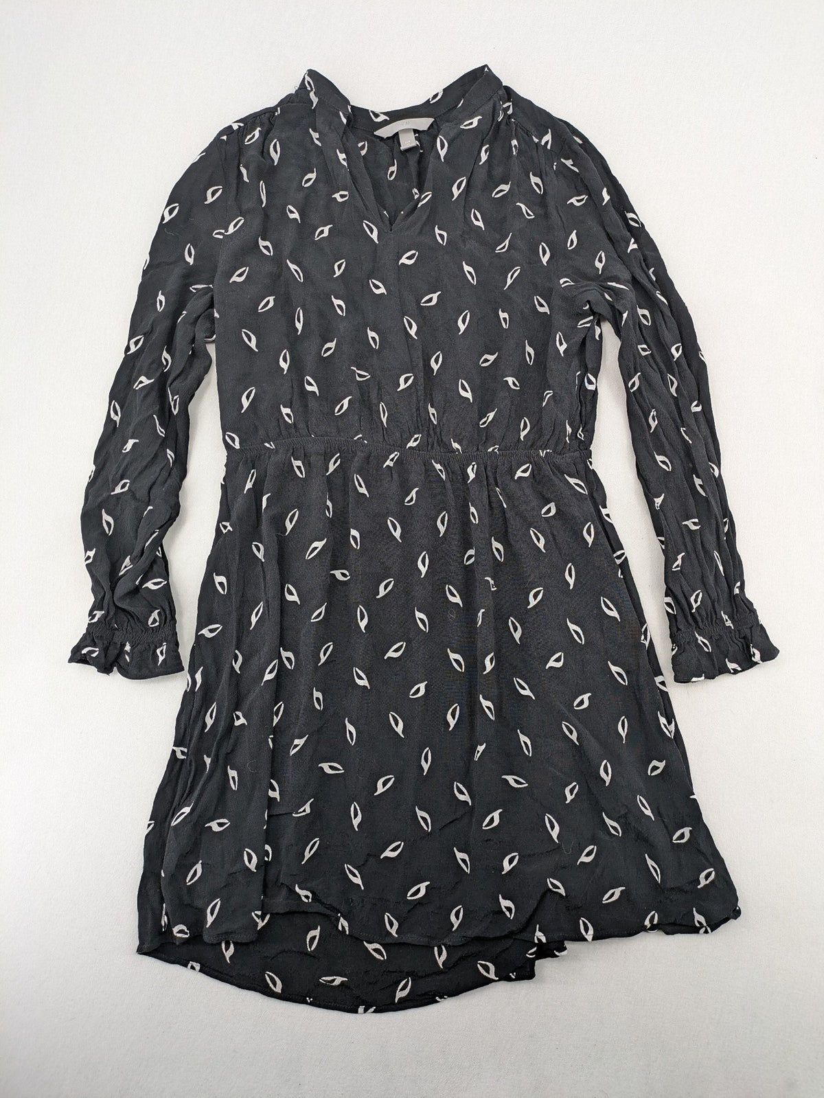 H&M grey and white dress with leaf print, V-neck, long sleeves, elastic cuffs.