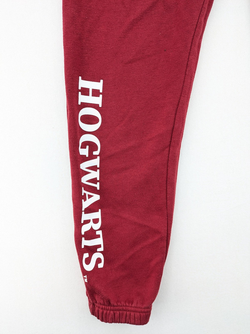 Harry Potter burgundy sweatpants featuring "HOGWARTS" print and Chibi graphic of Harry, Ron, Hermione.