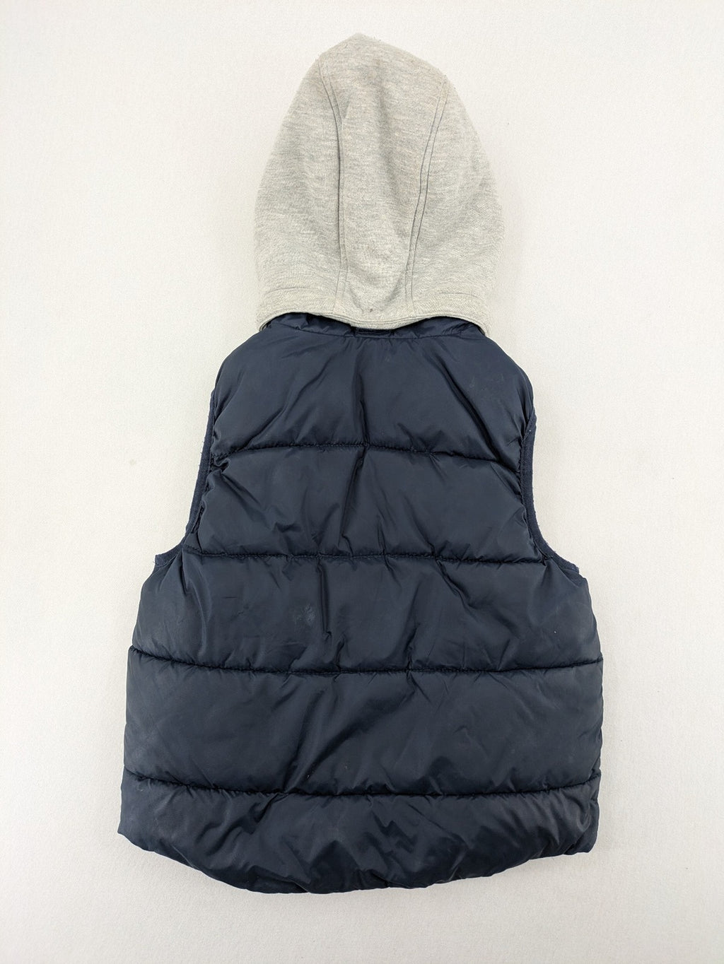 H&M navy puffer vest with grey hood and zip pockets for kids.