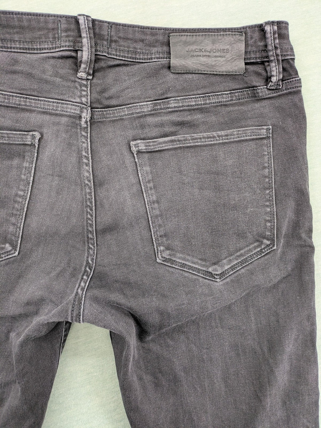 Jack & Jones black slim fit jeans faded wash stretch denim with logo detail.