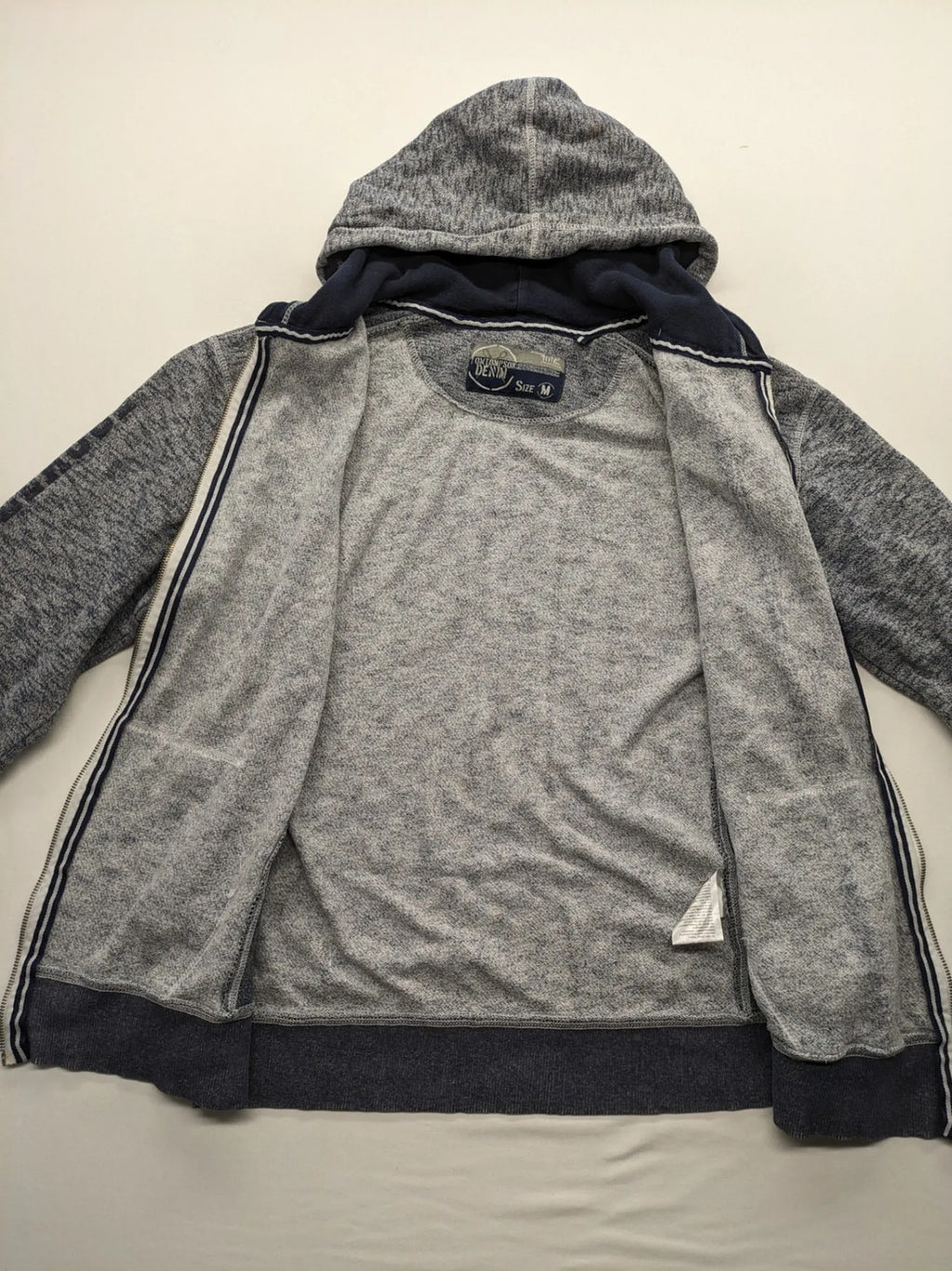Tom Tompson cream turtle neck jumper with dark blue accents and graphic details on sleeve.