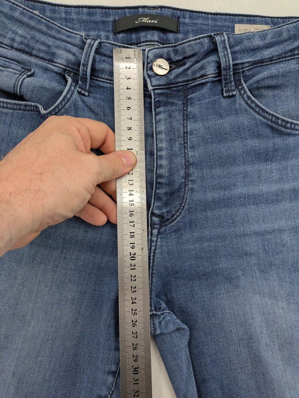 Mavi blue high rise super skinny jeans with medium wash and stretch denim material.