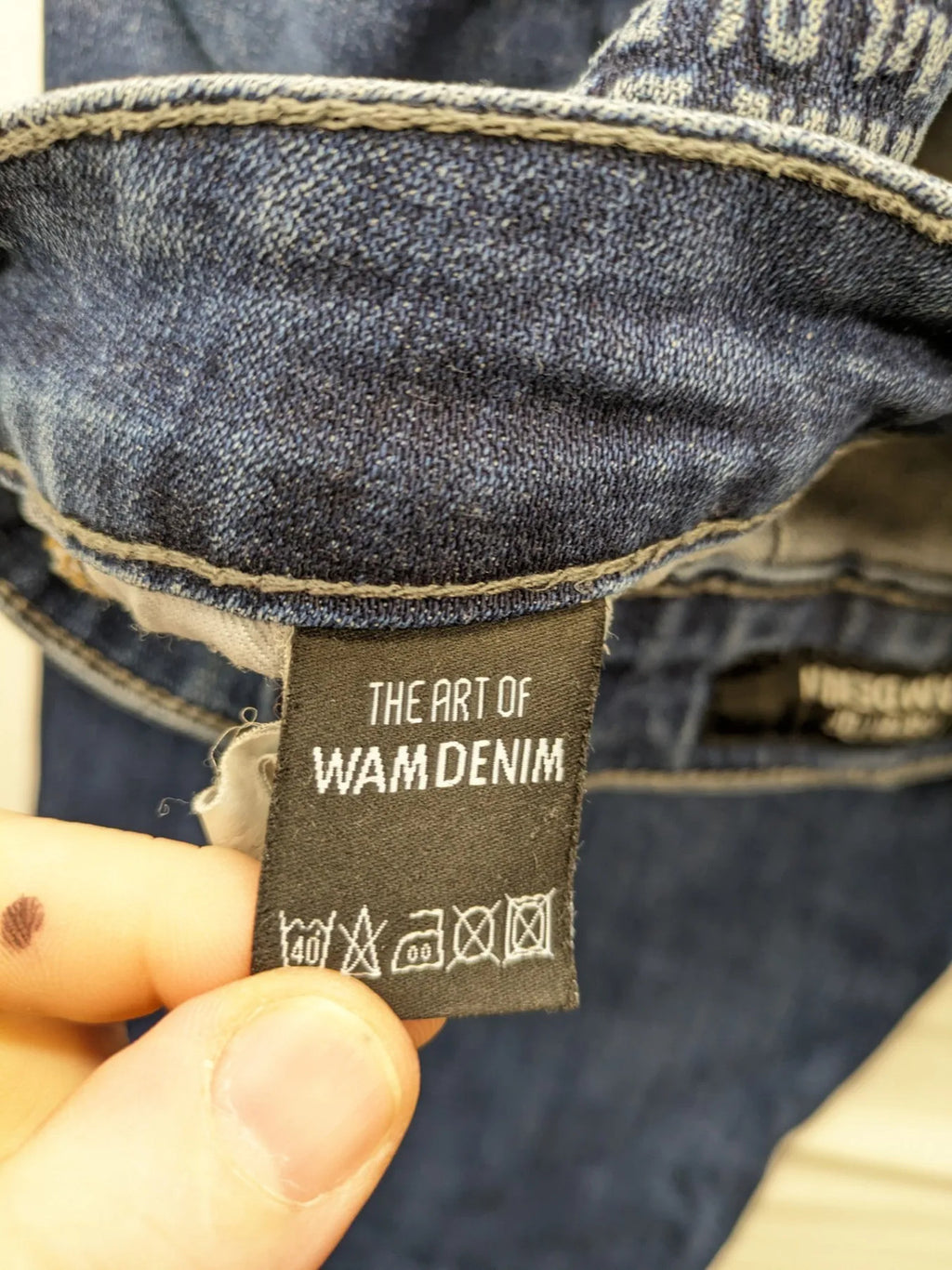 WAM Denim blue straight jeans with distressed details and button fly.