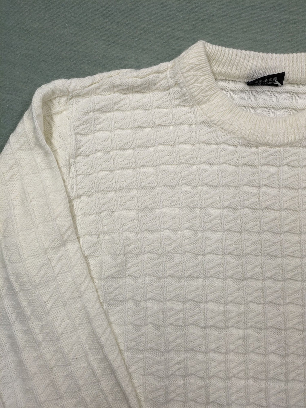 Haskalkan white turtle neck jumper with geometric textured pattern and ribbed cuffs.