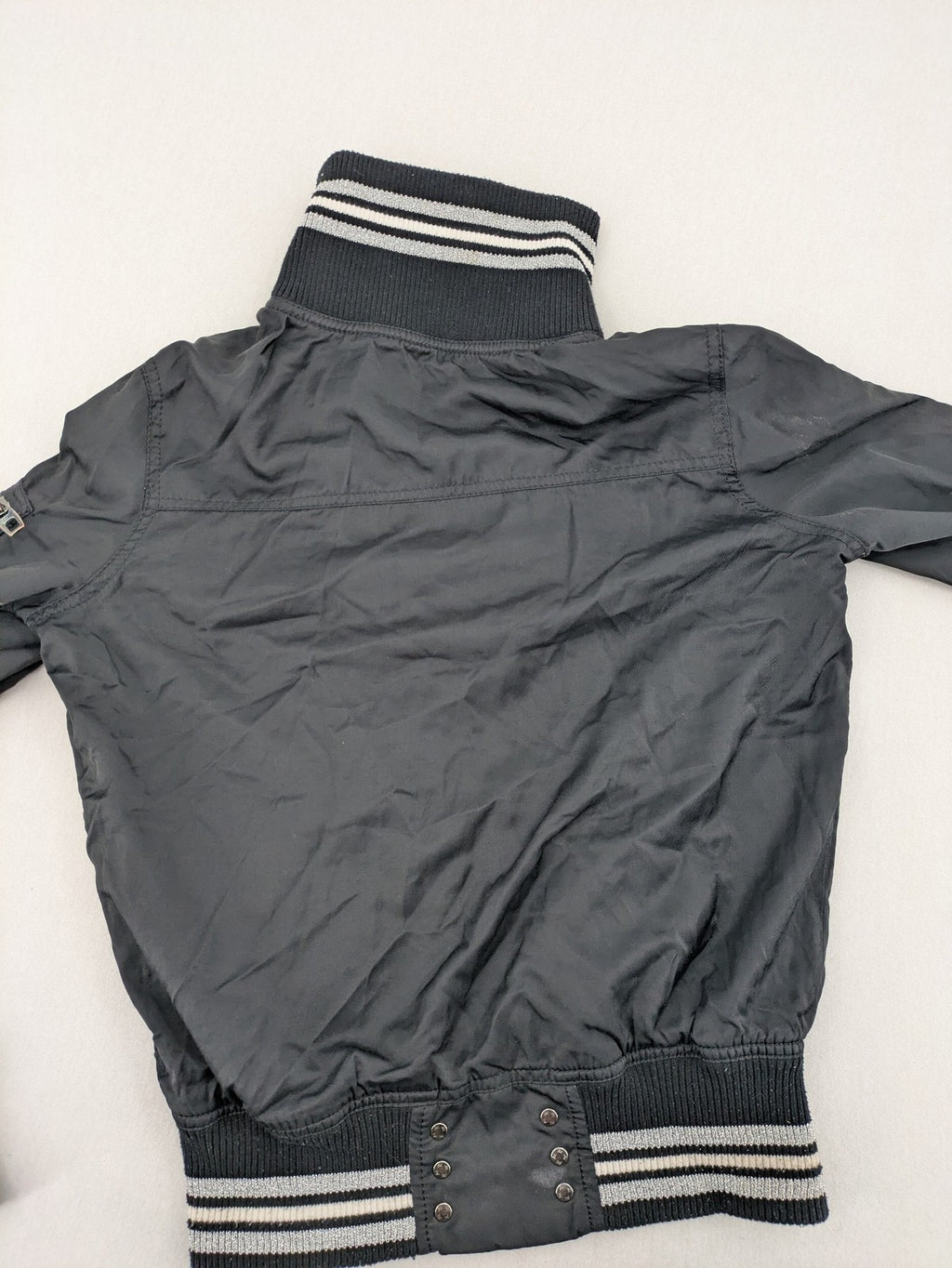 Ann Christine black bomber jacket with striped ribbed collar and cuffs, zip closure.