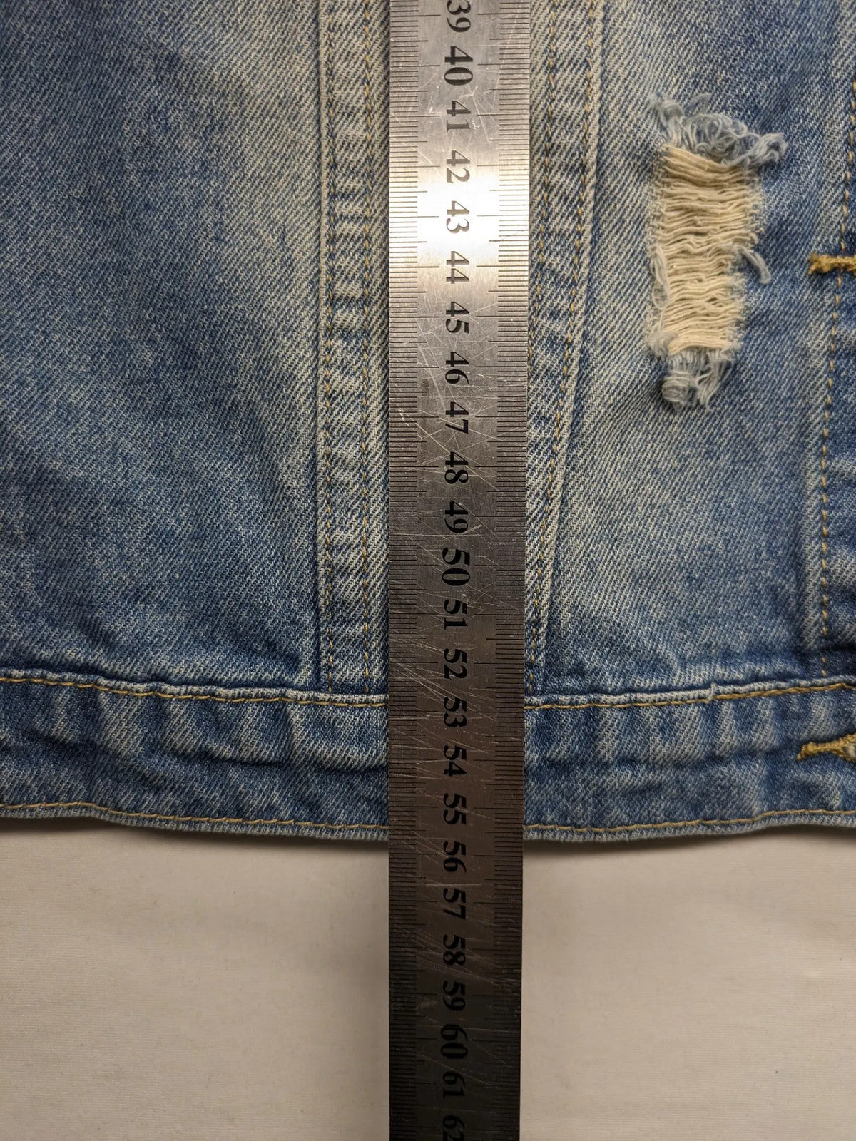 Damen Jeansjacke blau ärmellos mit Perlenverzierung, distressed Details und Knopfleiste.
