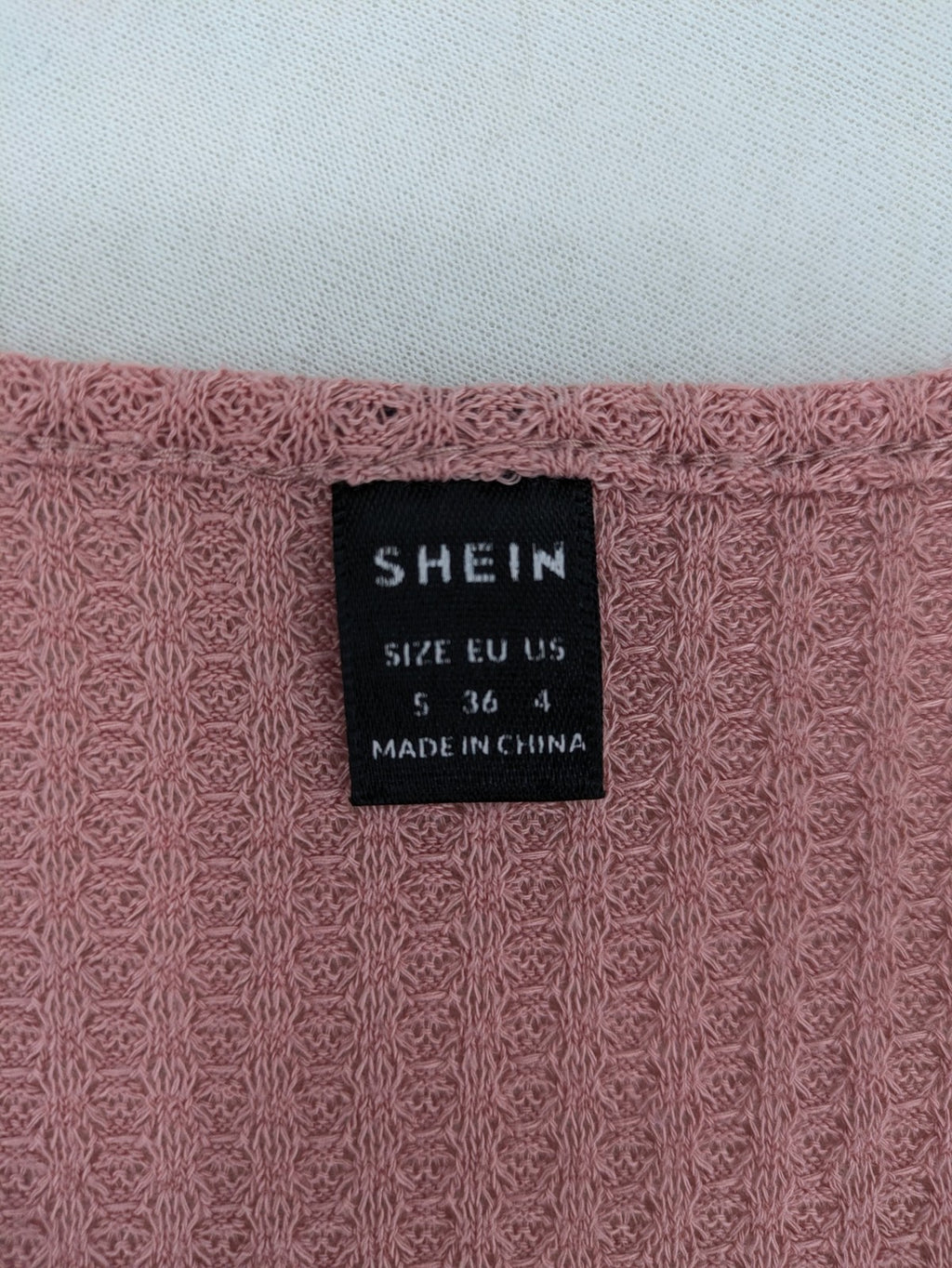 SHEIN pink top V-neck with ruffled waist and three decorative buttons, waffle knit fabric.