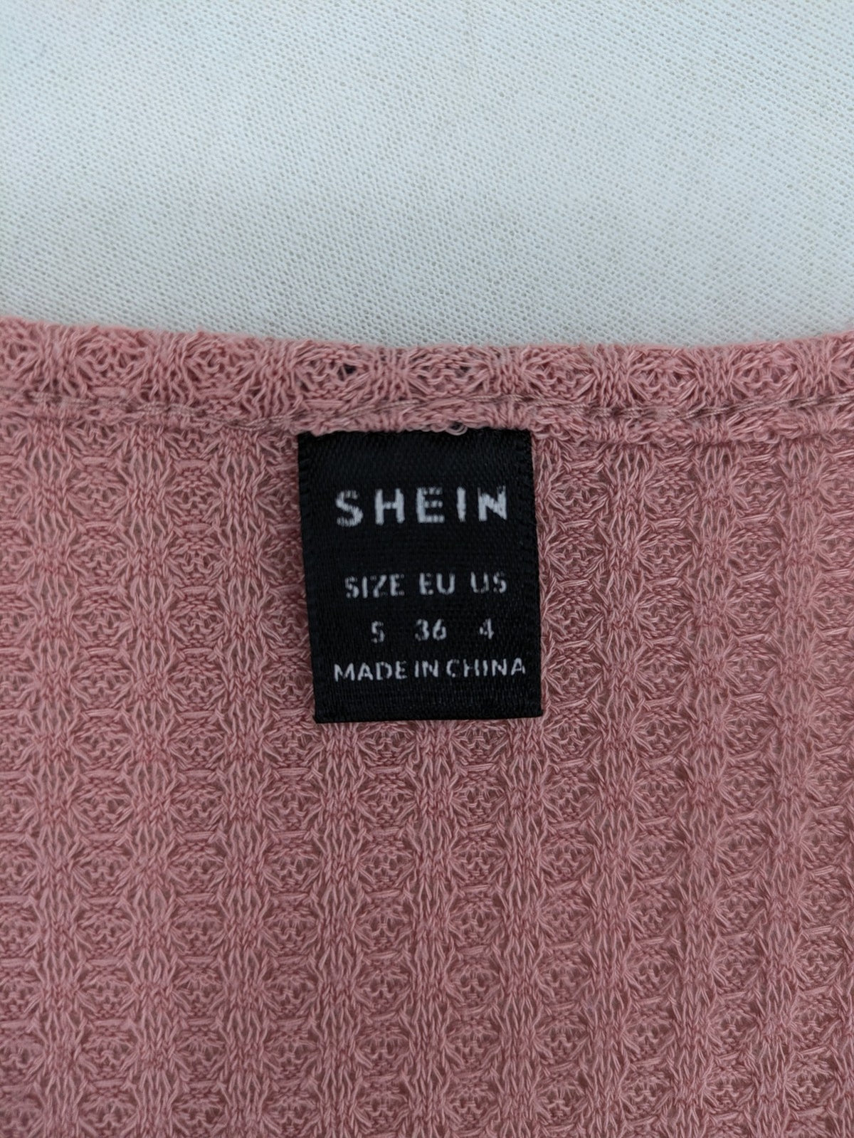 SHEIN pink top V-neck with ruffled waist and three decorative buttons, waffle knit fabric.