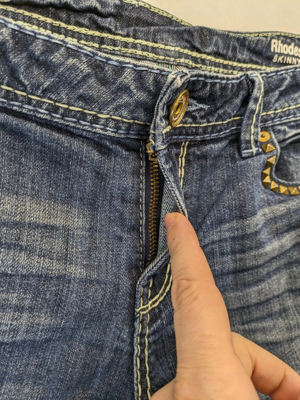 Rhodes blue skinny jeans with decorative studs and intricate embroidery on back pockets.