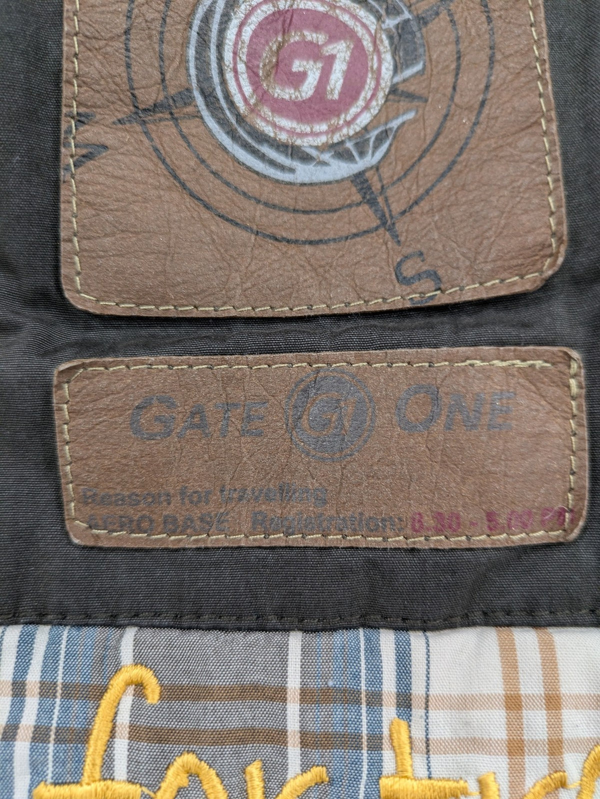 Gate One brown field jacket with plaid lining, multiple pockets, and zip-button closure.