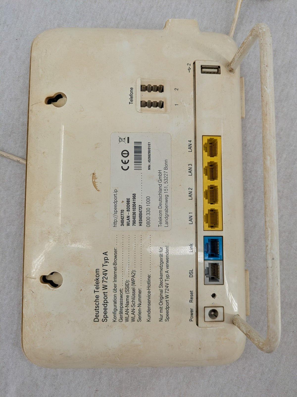Deutsche Telekom beige wireless router with multiple LAN and VoIP ports.