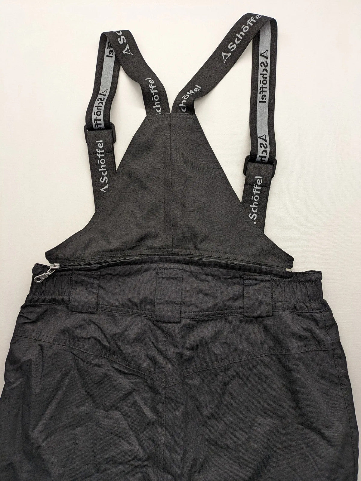 Schoffel black ski pants with adjustable straps, zip pockets, and snow gaiters.