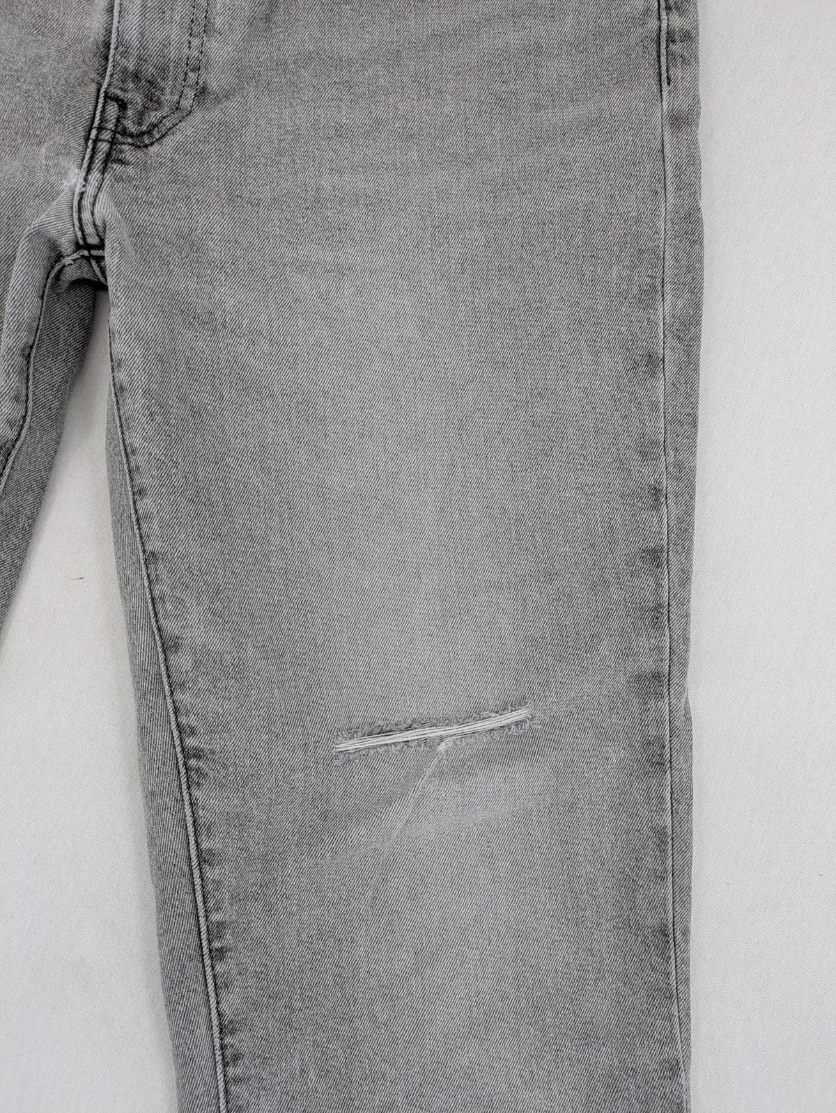 Levi's grey slim fit jeans with distressed knee details and classic logo patch.