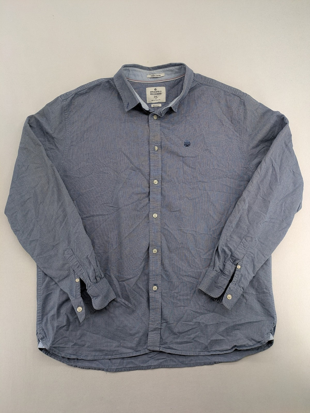 Springfield blue Oxford shirt with button placket and subtle logo embroidery.