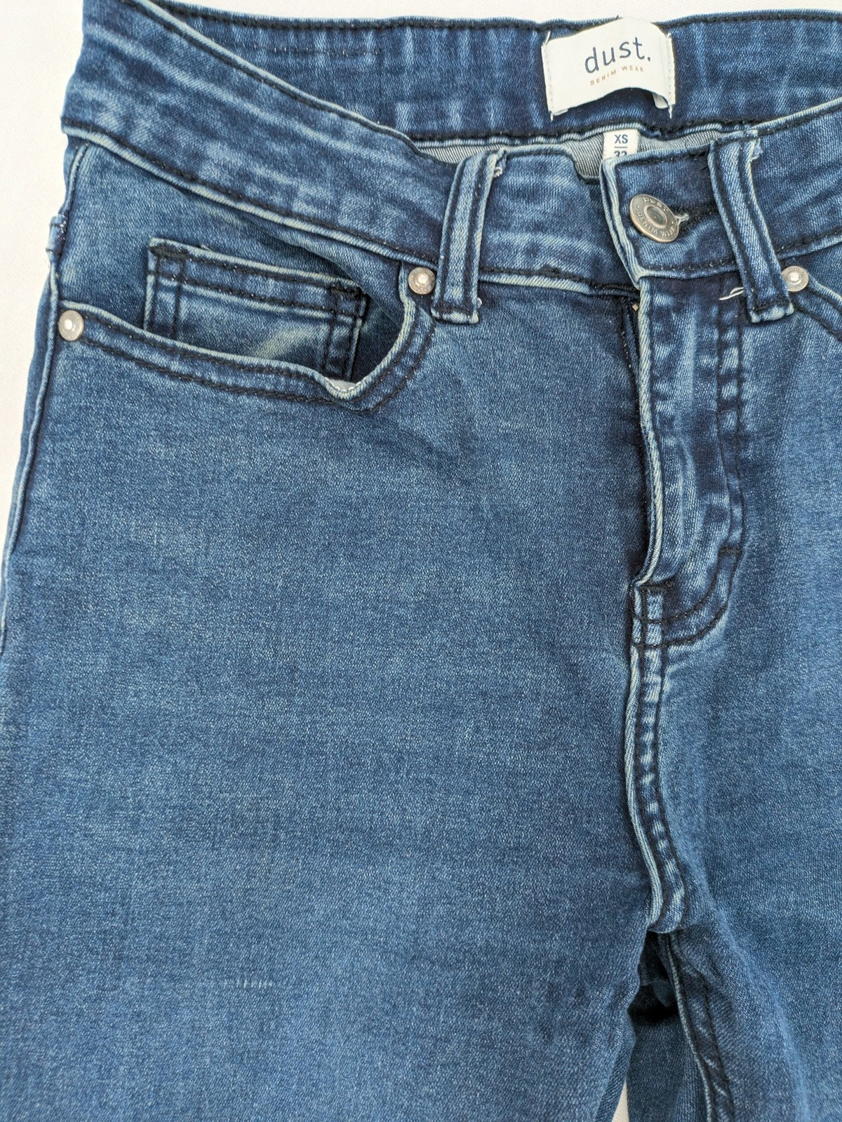 Dust blue skinny jeans with mid-rise waist and classic wash, stretch denim material.