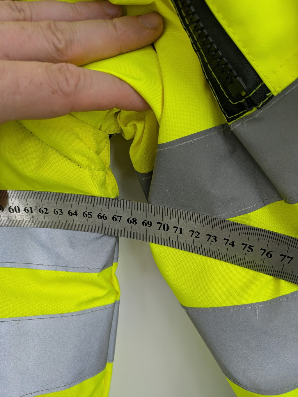Hüren OHG grey and neon yellow safety jacket with reflective stripes and zippered arm pocket.