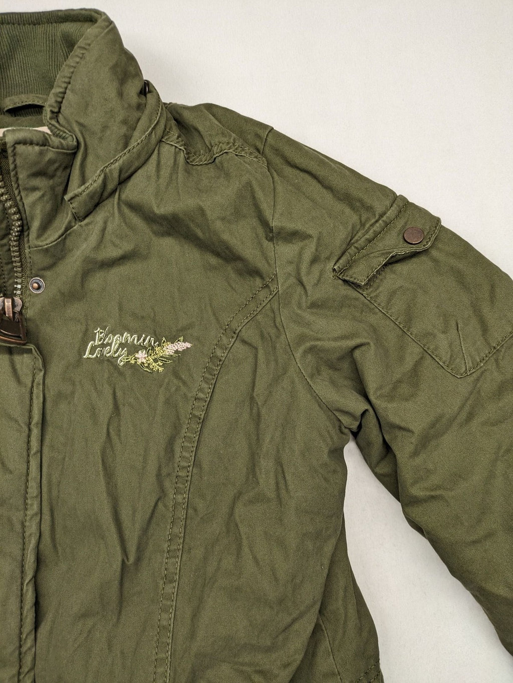 Vp Fashion khaki parka coat with "Bloomin' Lovely" floral embroidery and quilted lining.