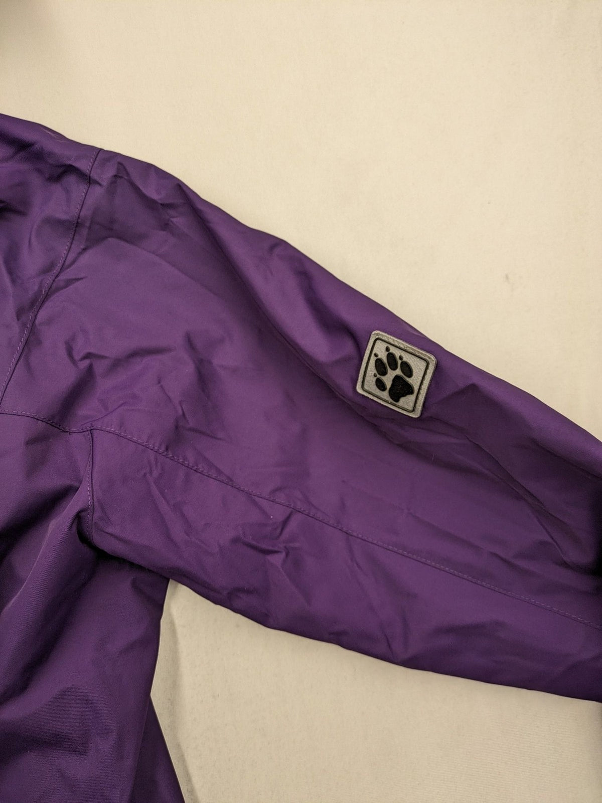 Jack Wolfskin purple outdoor jacket with adjustable hood and full zip, lightweight Stormlock material.