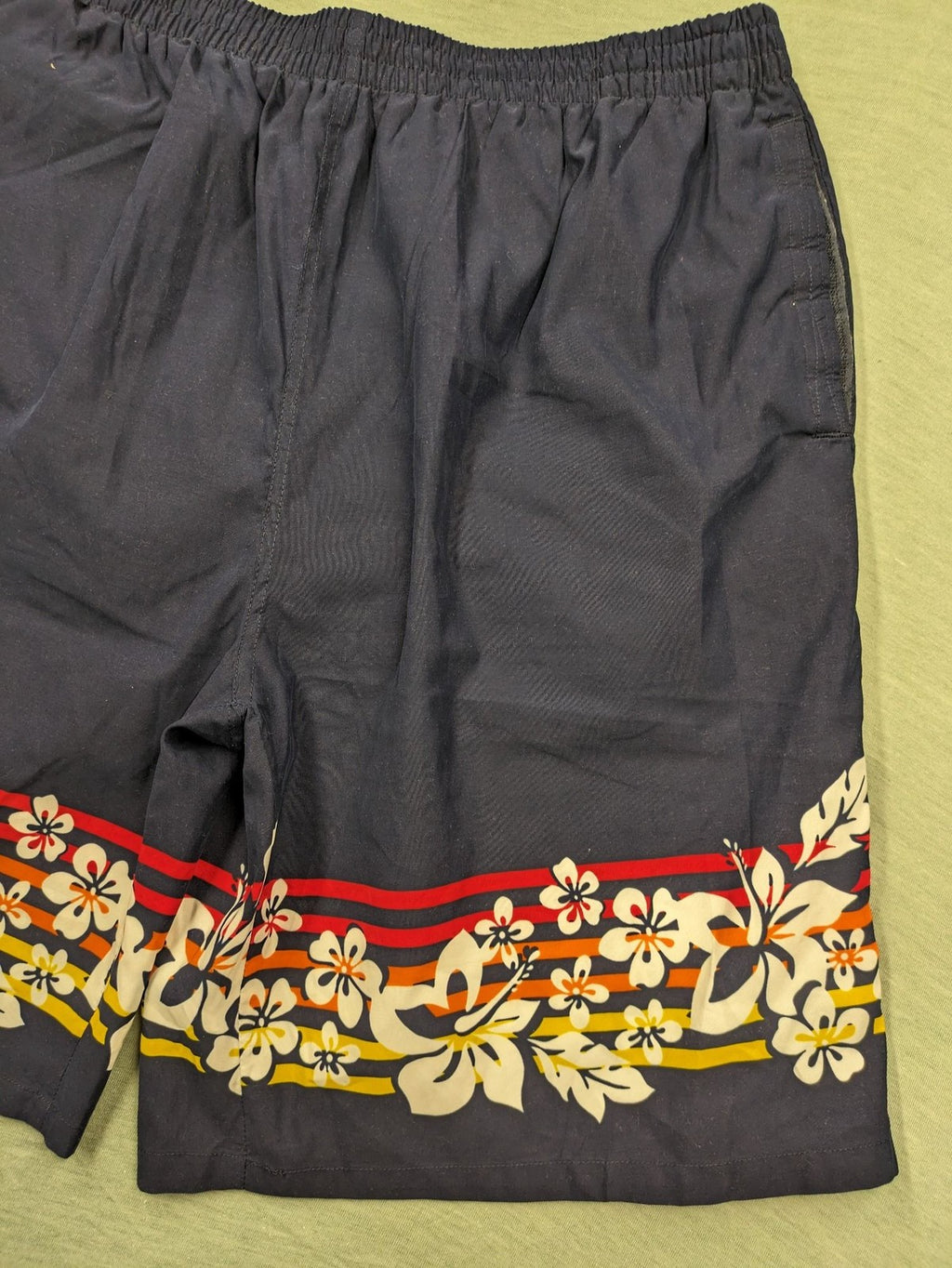 Muster multi swim shorts dark blue with vibrant Hawaii floral pattern and elastic waistband.