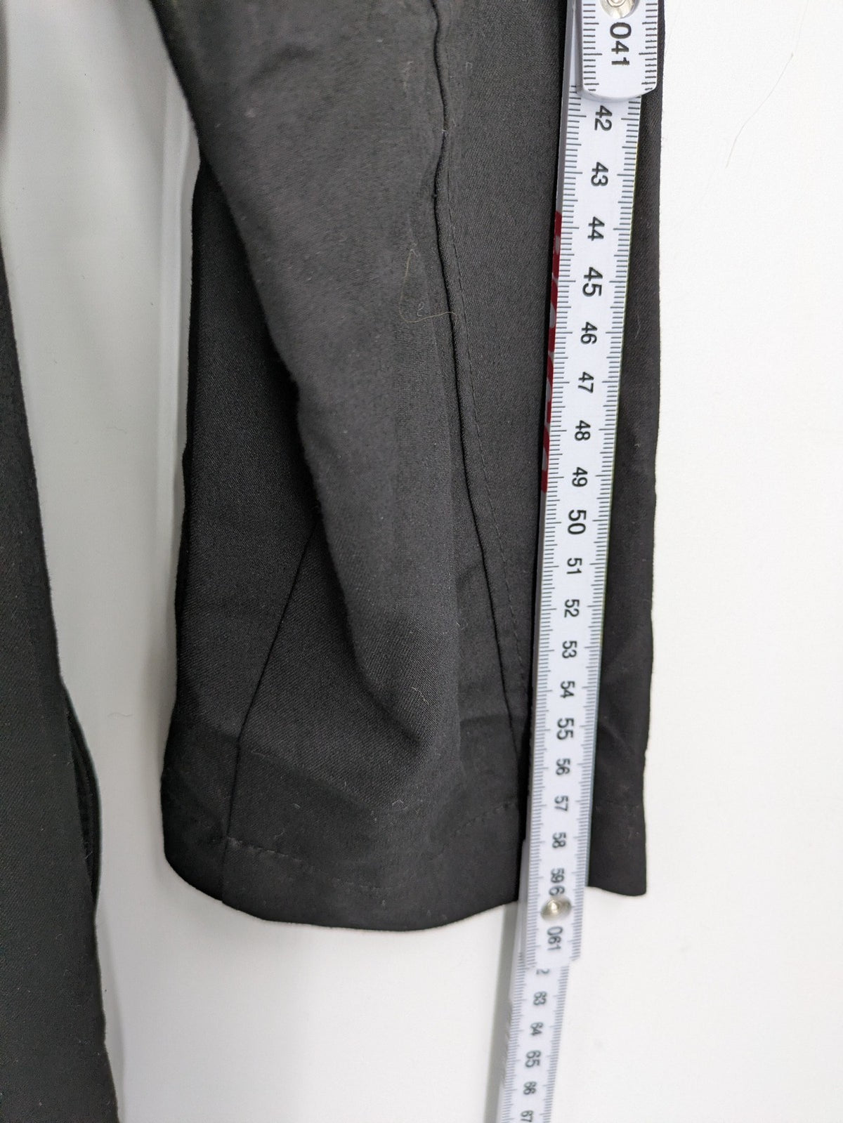 Alvina black trench coat with lace collar and gold buttons, belted waist design.