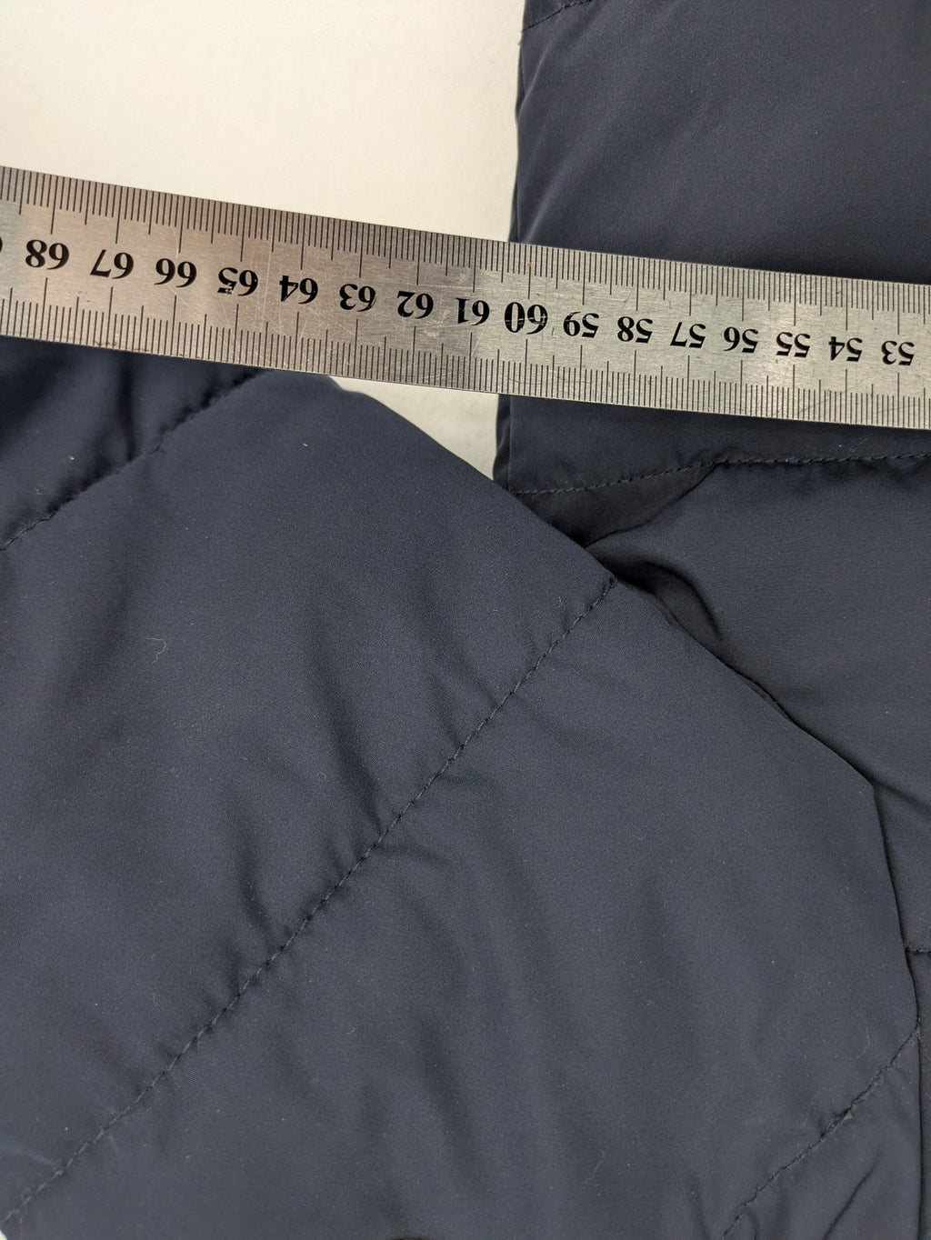 Tom Tailor navy puffer jacket with quilted design and adjustable hood, featuring multiple pockets.