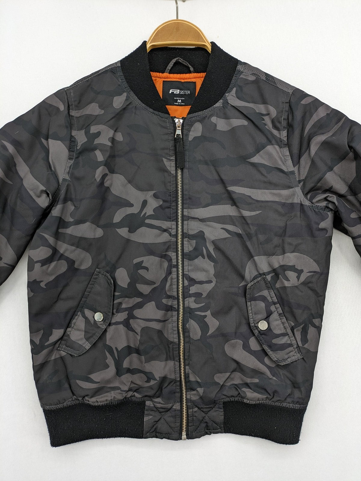 FB Sister orange bomber jacket with gray camouflage pattern and quilted lining.