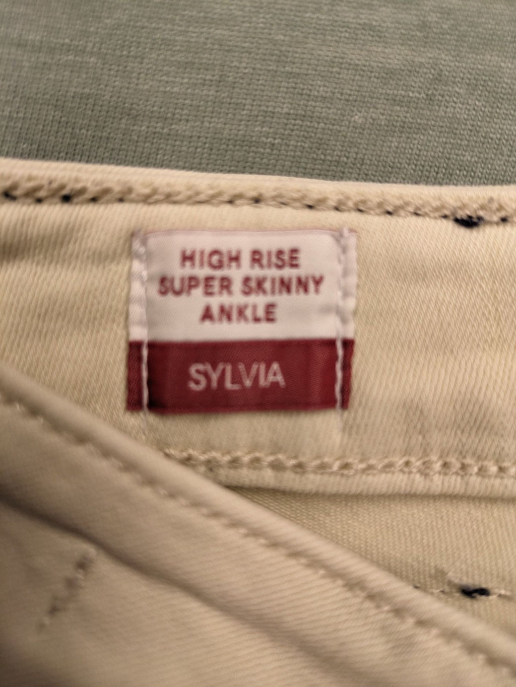 Tommy Jeans beige high rise skinny ankle jeans with logo patch and stretch fabric.