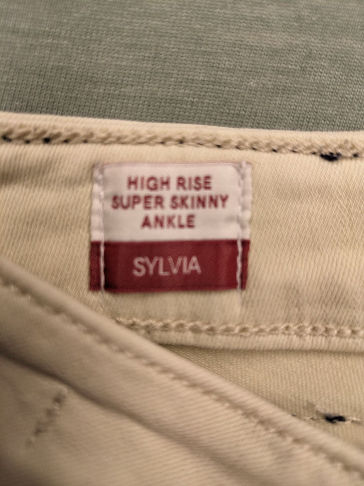 Tommy Jeans beige high rise skinny ankle jeans with logo patch and stretch fabric.
