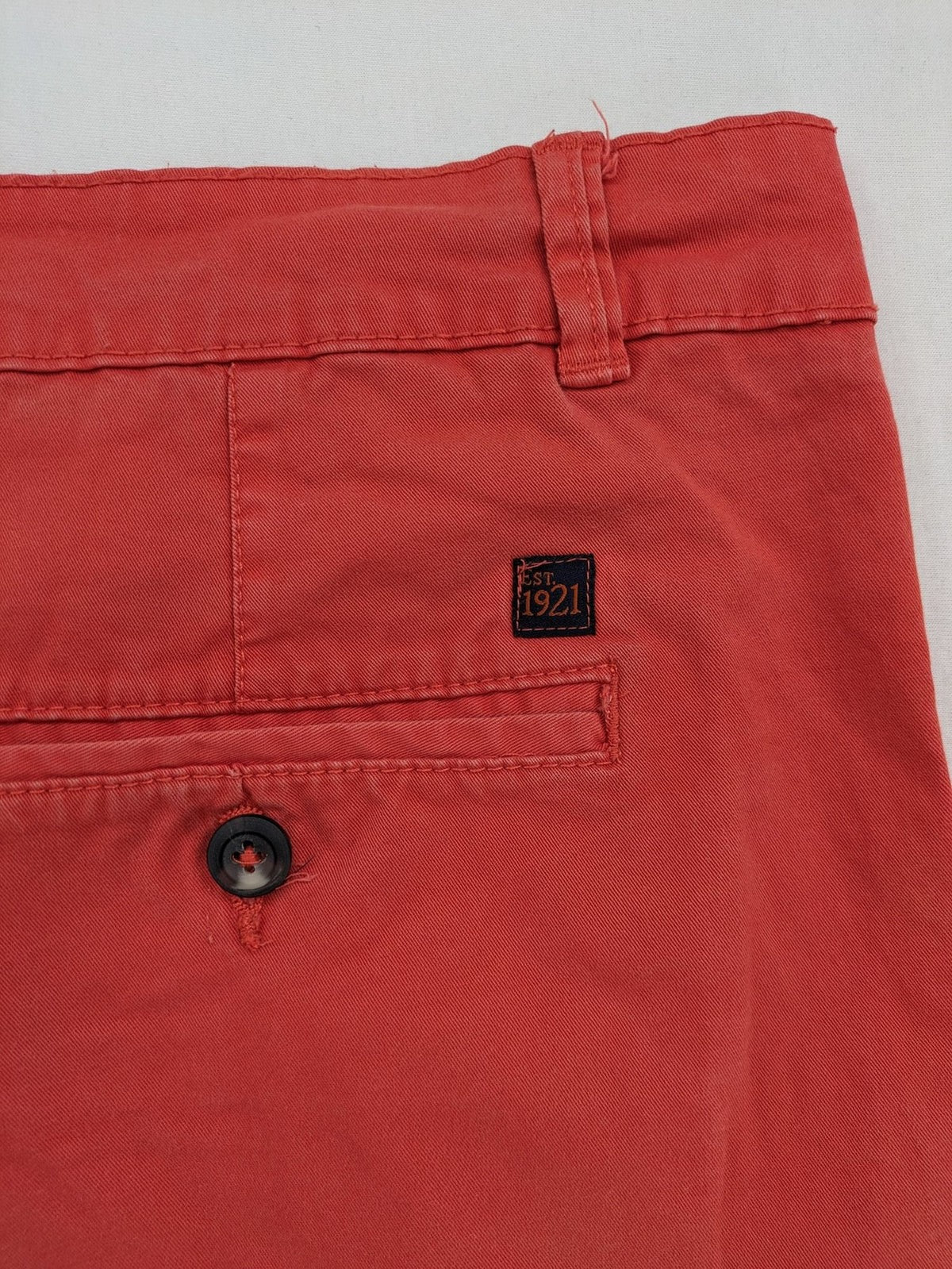 Chino orange shorts flat front with Est. 1921 label and comfortable fit.