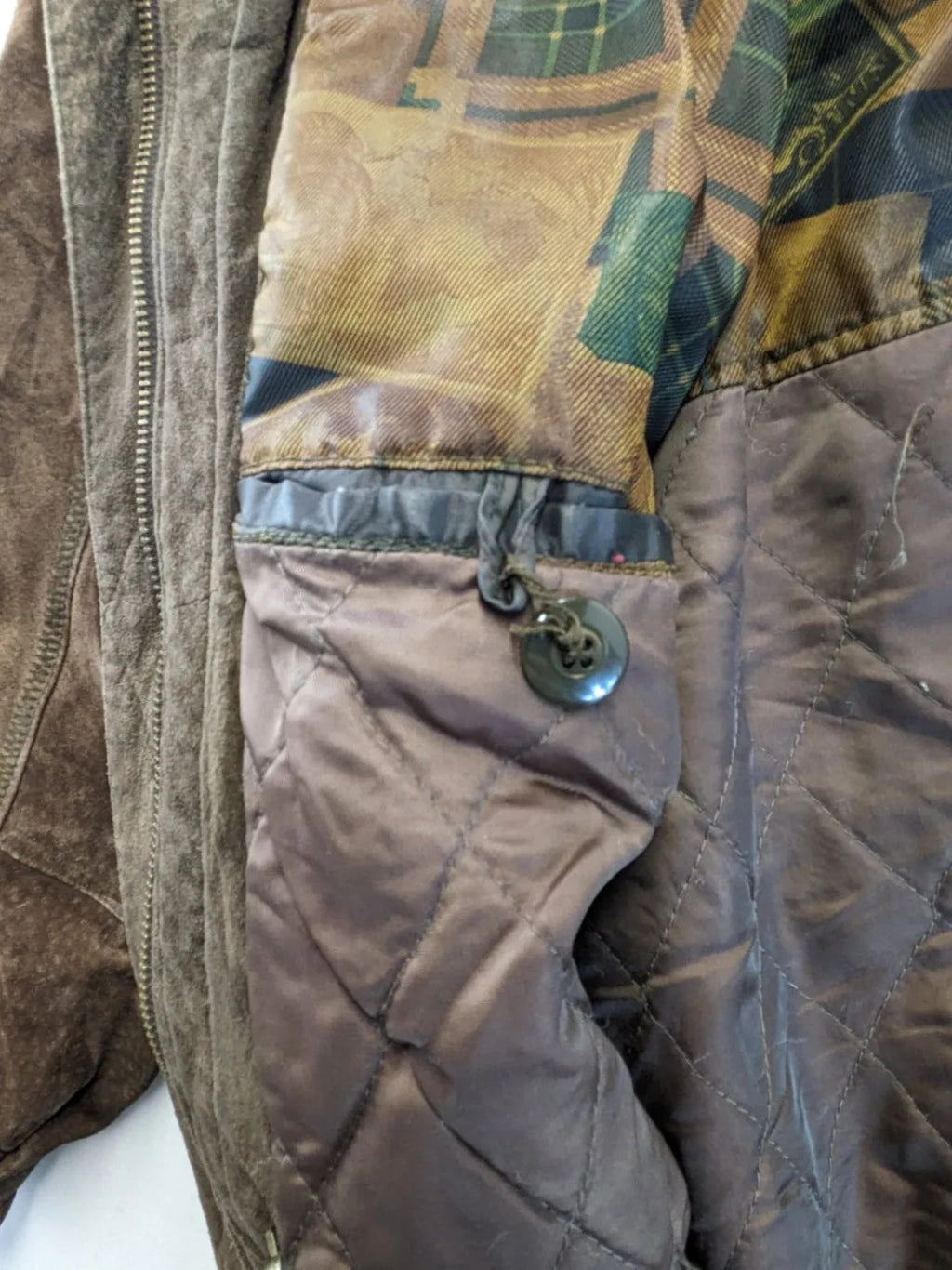 Vintage brown leather jacket with graphic lining, zip closure, and button placket.