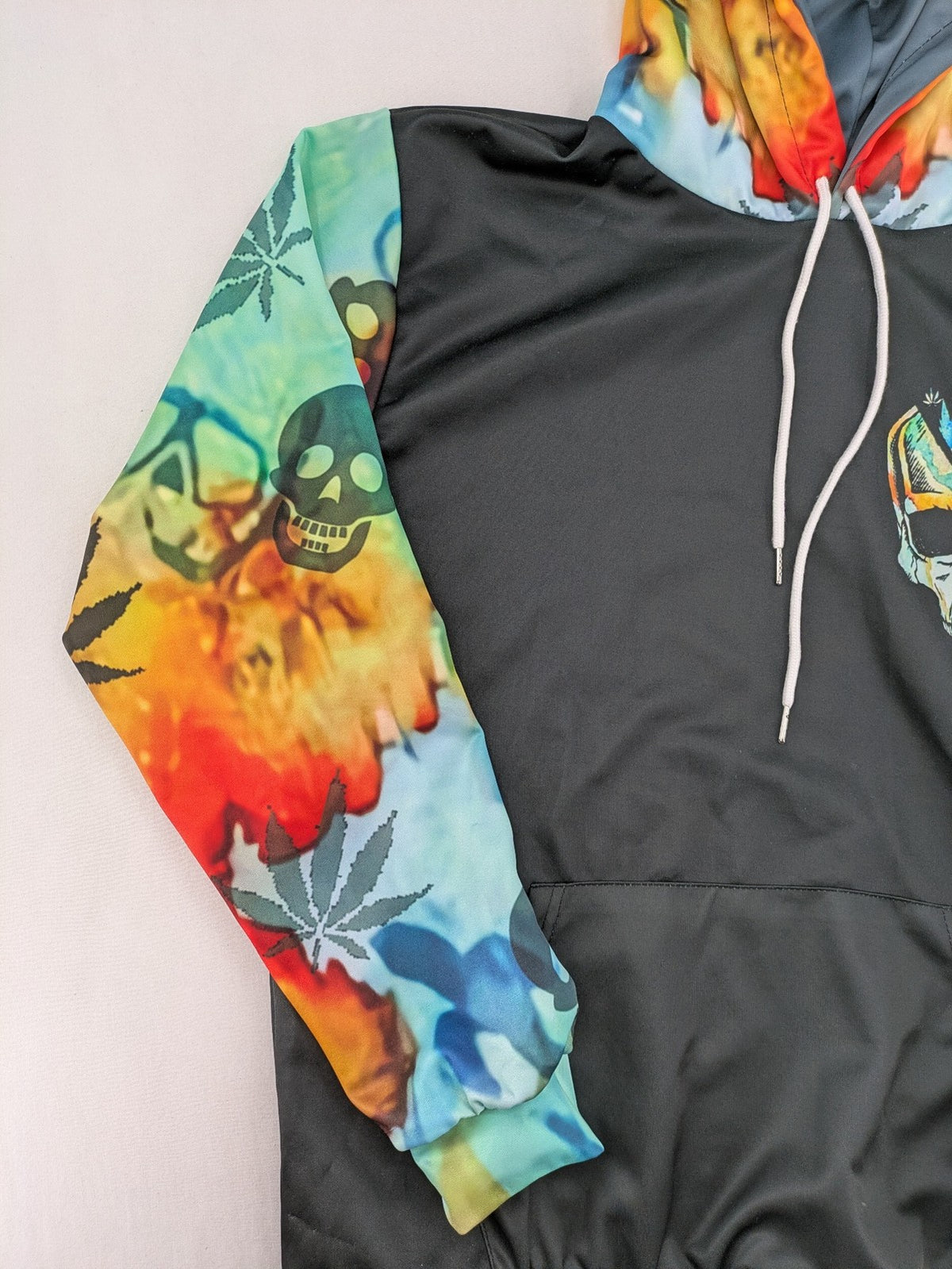 Skull tie-dye hoodie blue green with cannabis leaf graphic and bold text.