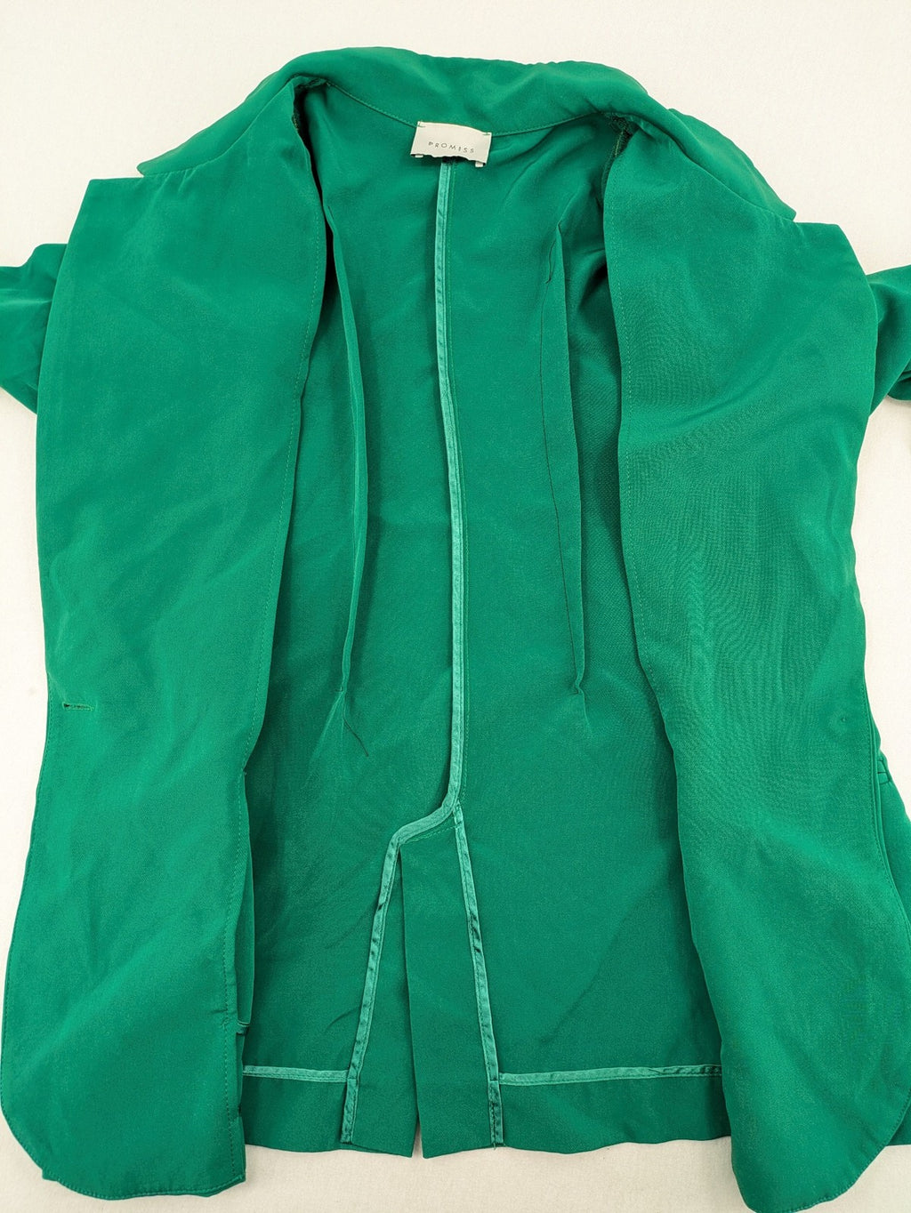 Promiss green blazer jacket single-button design with notch lapels and decorative pockets.