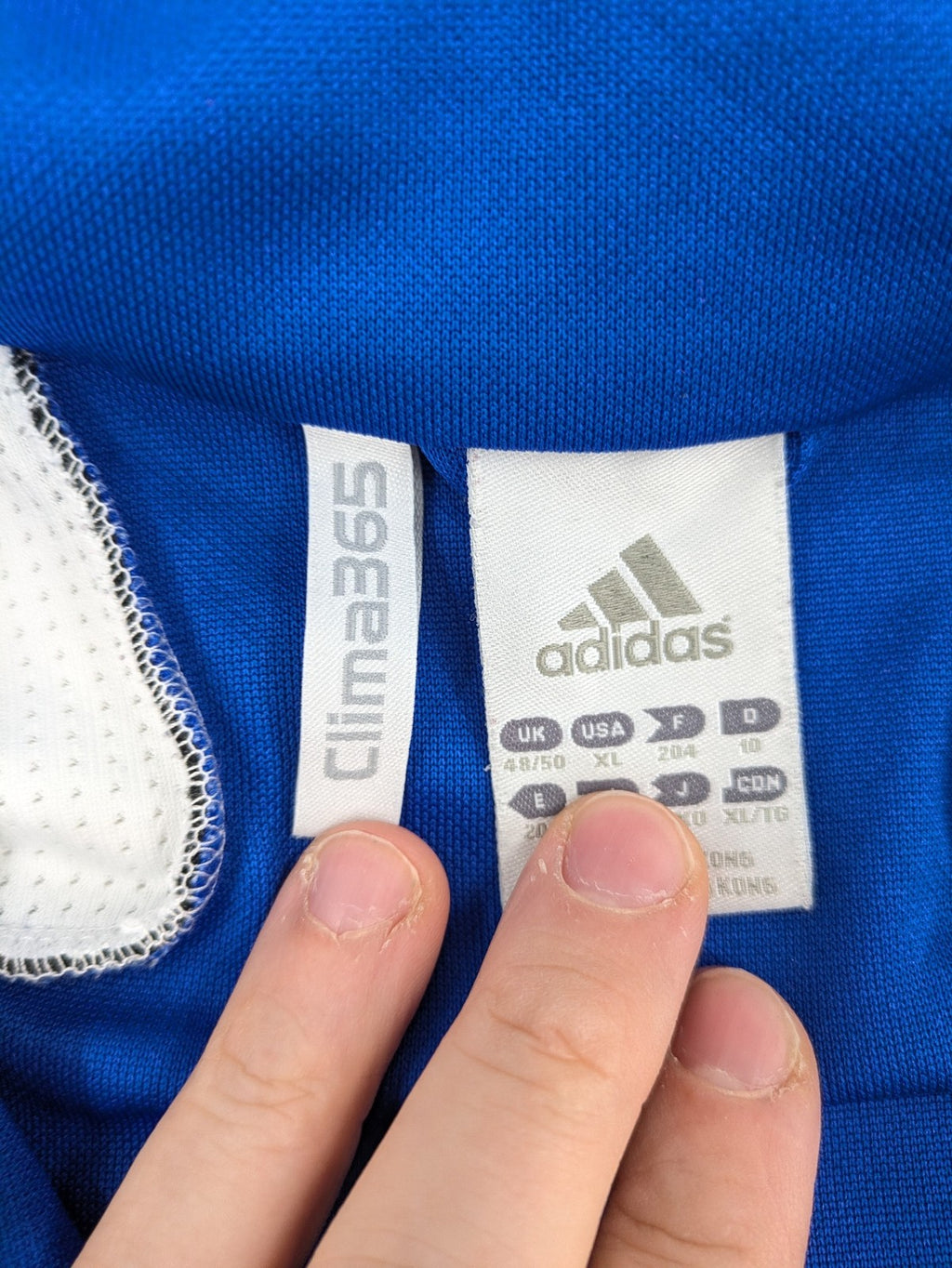 Adidas blue long sleeve top with white three stripes and 1/4 zip collar.