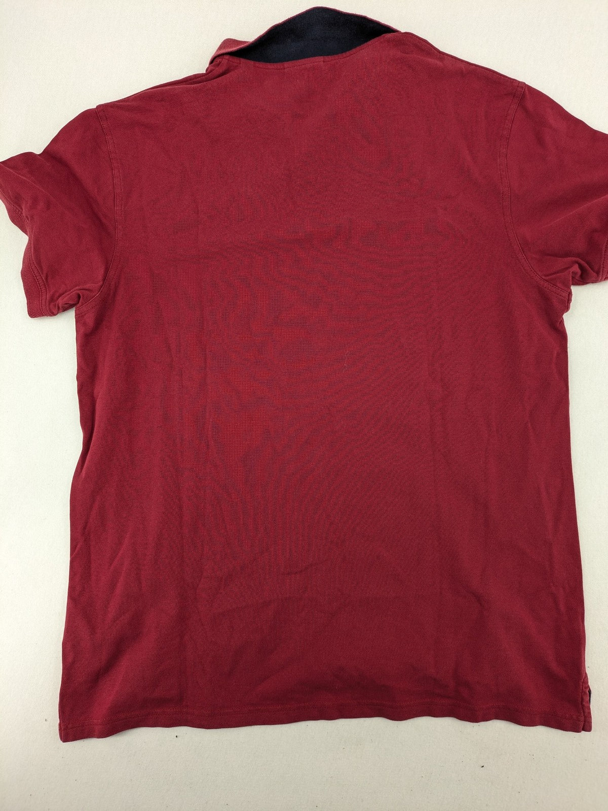 GANT burgundy polo shirt with embroidered shield logo and contrasting navy collar details.