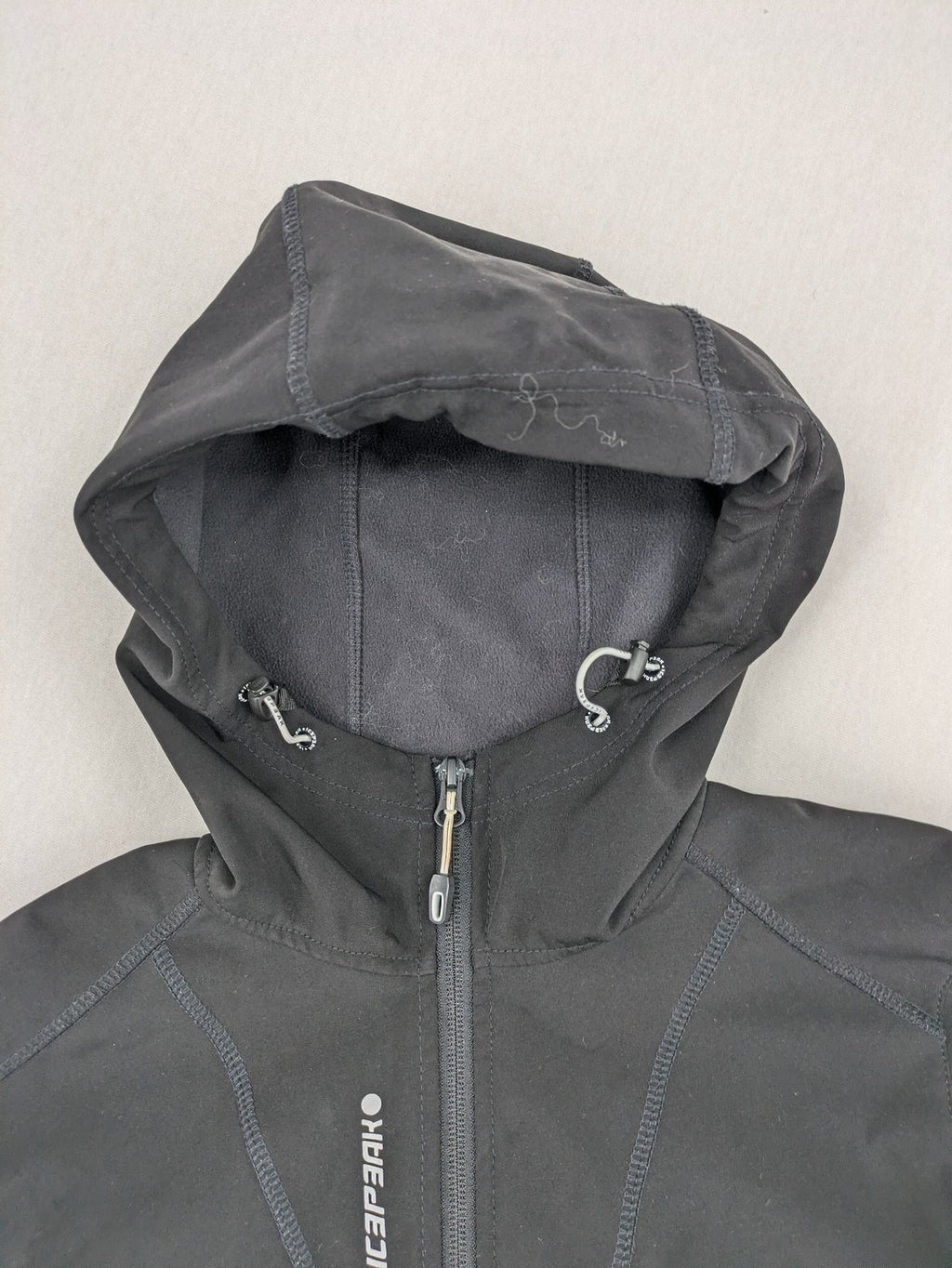 Icepeak black softshell jacket with fleece lining, adjustable hood, and zippered pockets.