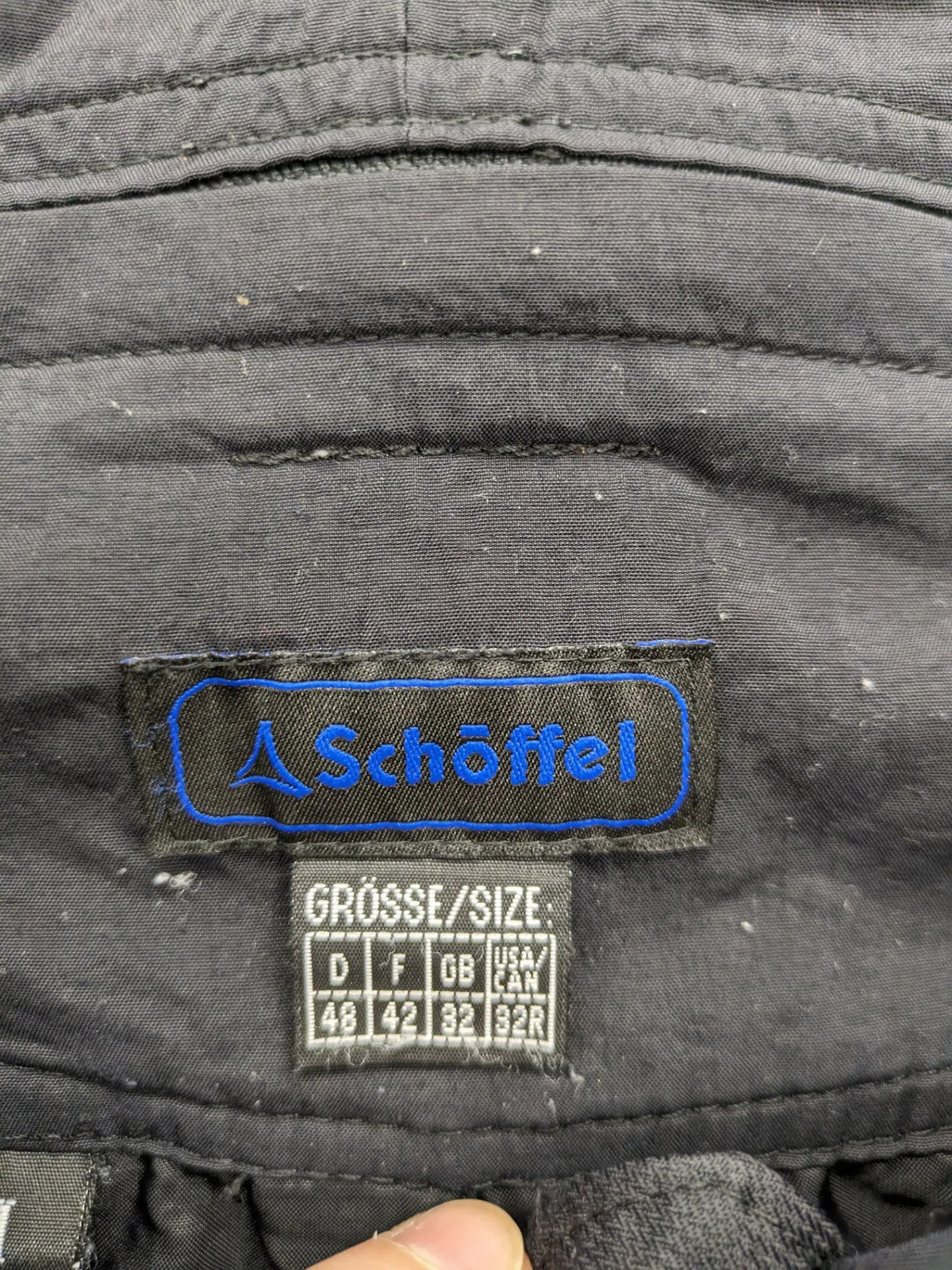 Schoffel black ski pants with adjustable straps, zip pockets, and snow gaiters.