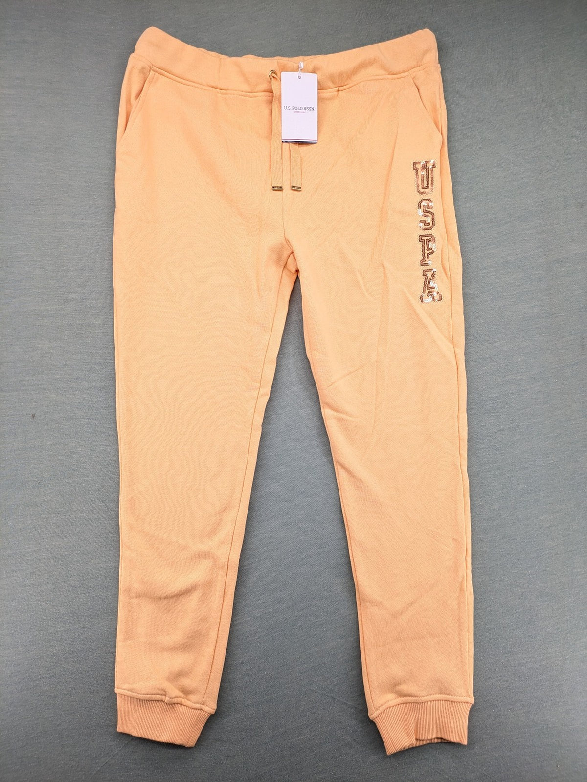 U.S. Polo Assn. orange sweatpants slim fit with sequin USPA logo on leg.
