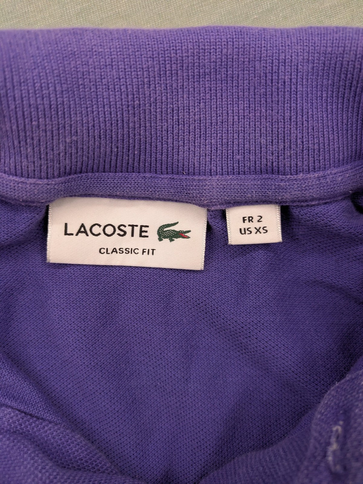 Lacoste purple polo shirt classic fit with embroidered crocodile logo and short sleeves.