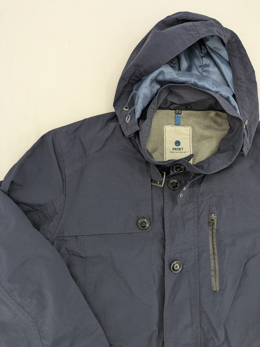 Reset navy parka jacket windproof with adjustable hood and zippered chest pocket.