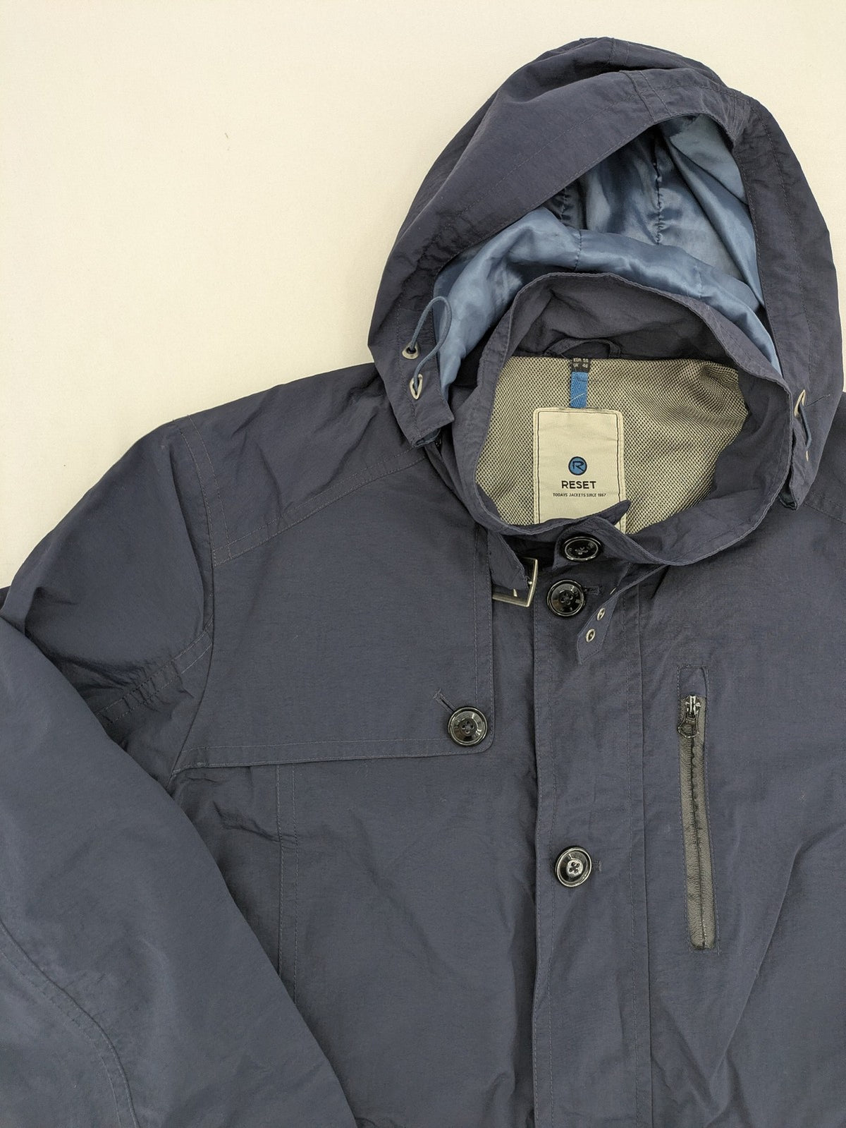 Reset navy parka jacket windproof with adjustable hood and zippered chest pocket.